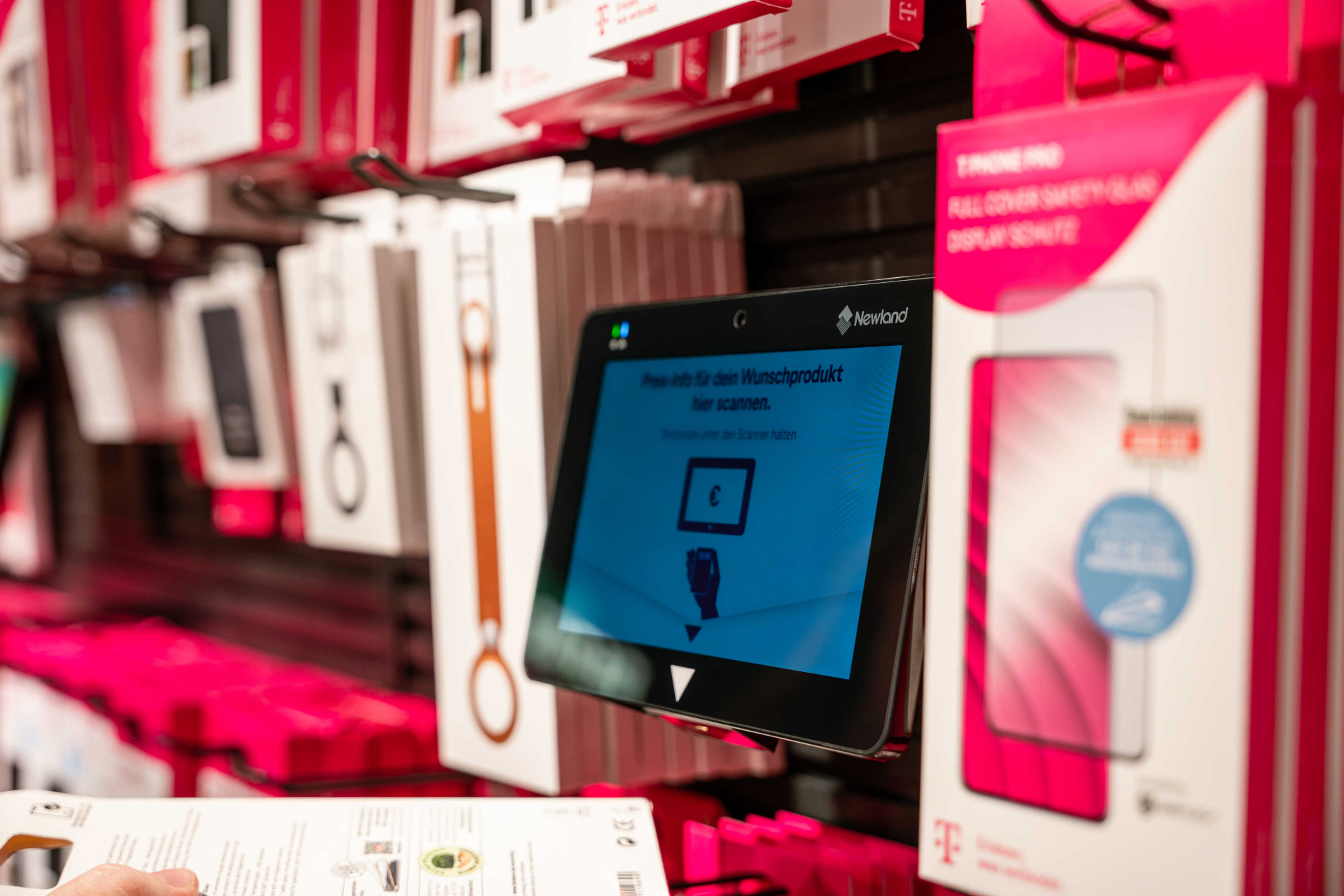 Image of the Newland NQuire 750 Stingray Micro Kiosk for barcode scanning and price checking at the Deutsche Telekom store.