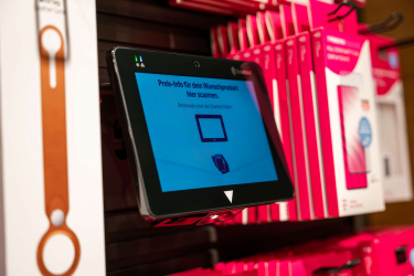 The NQuire 750 in Telekom Stores takes over price checking and labelling. The photograph displays the NQuire 750 Micro Kiosk Barcode scanner between the products.